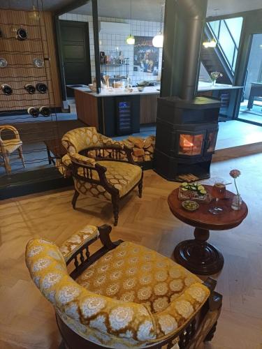 a living room with a fireplace and chairs and a table at B&B Boudevino in Lekkerkerk