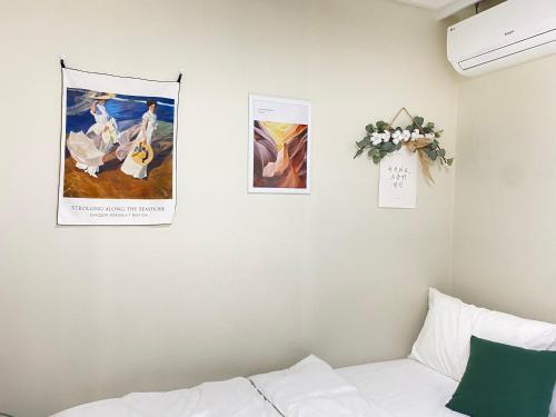 a bedroom with three pictures on the wall and a couch at 달빛그리기Moonlight in Daegu