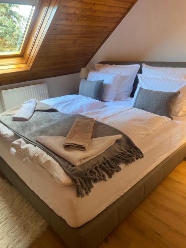 a large bed with a cross on it in a bedroom at Erelia Cottage in Bük