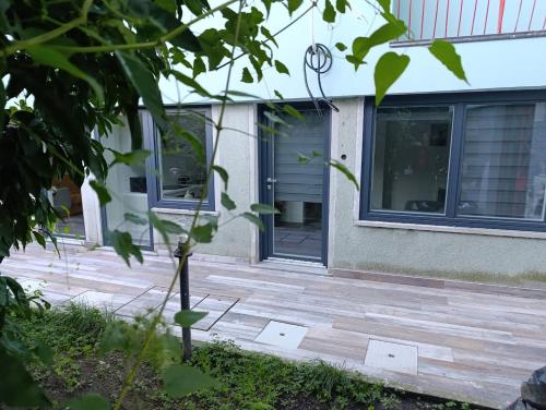 una casa con un patio de madera con una puerta en Callisto, en Dervio