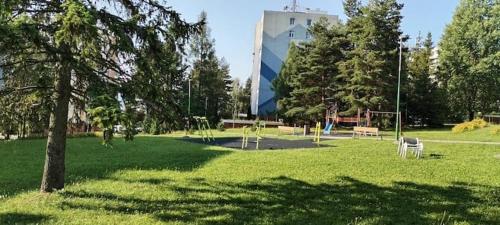 a park with benches and trees and a building at Apartmán Líška v Tatranskej Štrbe in Tatranska Strba