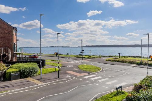 eine leere Straße neben einem Wasserkörper in der Unterkunft Quai Des Pecheurs - With Views from Bedroom Overlooking the Harbour in Poole