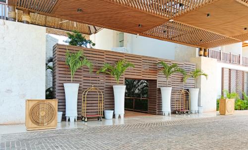 a building with white vases with plants in them at Hotel Mundo Maya Chichén Itzá in Chichén-Itzá