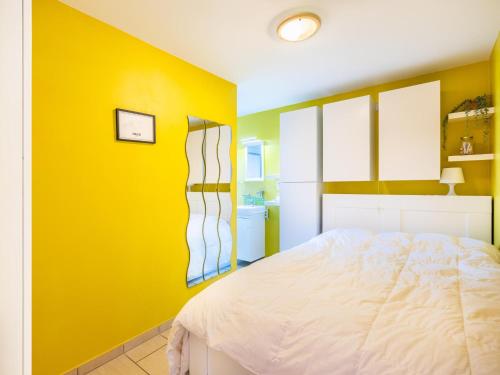 a bedroom with yellow walls and a white bed at Vicky derde in Galopen