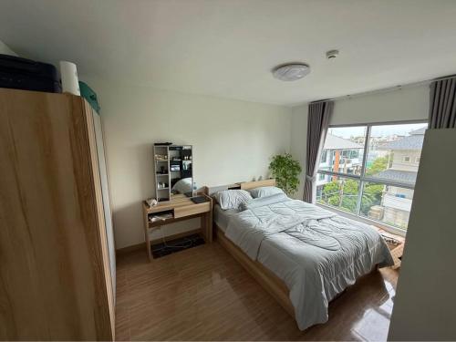a bedroom with a bed and a desk and a window at 1 bd at s&s sukhumbit in Amphoe Phra Khanong