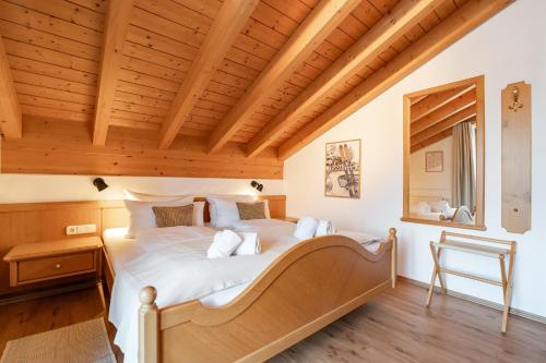a bedroom with a large bed with a wooden ceiling at Landhaus Christine in Oberstdorf