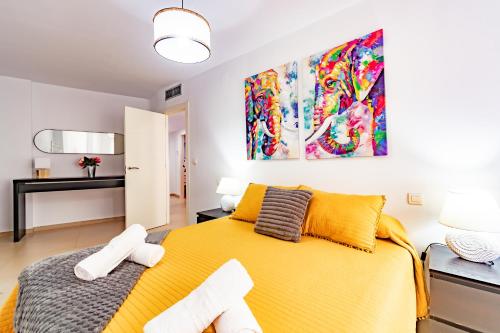 a bedroom with a yellow bed with two towels at Avenida Principal junto a la Playa - by Aloha Palma in Águilas