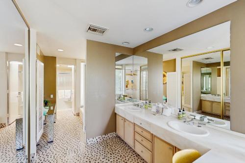 a bathroom with two sinks and two mirrors at Indian Wells Elegance in Indian Wells