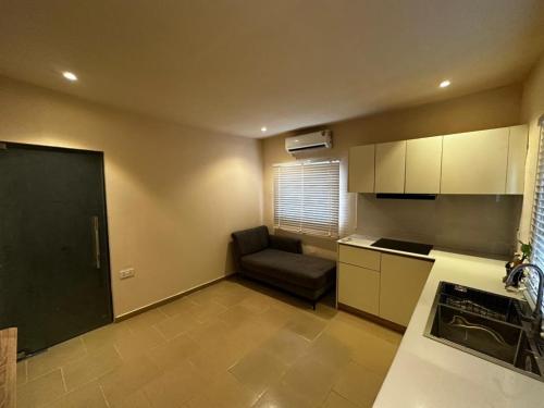 a small kitchen with a couch in a room at One Bedroom Studio Apartment in Benin City
