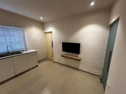 a kitchen with a flat screen tv on the wall at One Bedroom Studio Apartment in Benin City