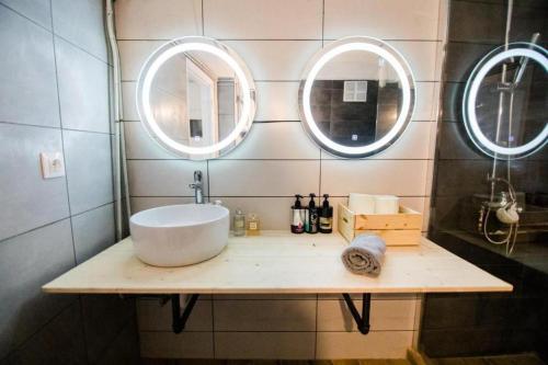 a bathroom with a sink and two mirrors at Quiet room, hall, shared bathroom and kitchen in Athens