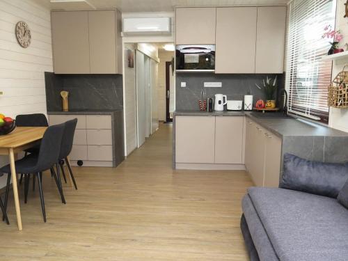 een keuken en woonkamer met een tafel en een bank bij Houseboat Rosie in Praag