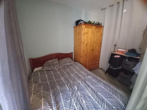 a bedroom with a bed and a wooden cabinet at 100m lac et piste cyclable avec parking gratuit in Sévrier