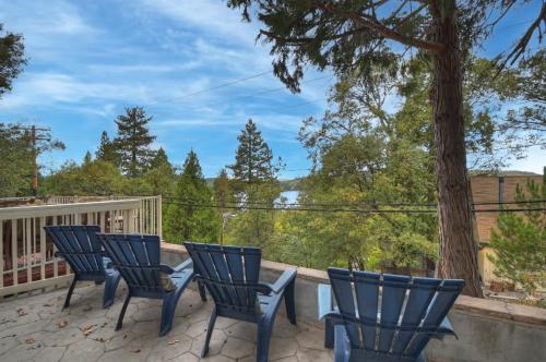 a deck with four chairs and a tree at Emerald Arrowhead Haus - For 6 in Lake Arrowhead