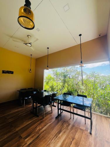 una sala da pranzo con tavoli e una grande finestra di Casa Nube Resort Munnar a Munnar