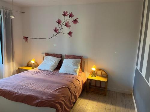 a bedroom with a bed with a branch on the wall at La maison bleue 
