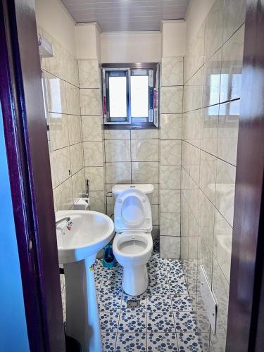 a bathroom with a toilet and a sink at Residence JTC in Douala