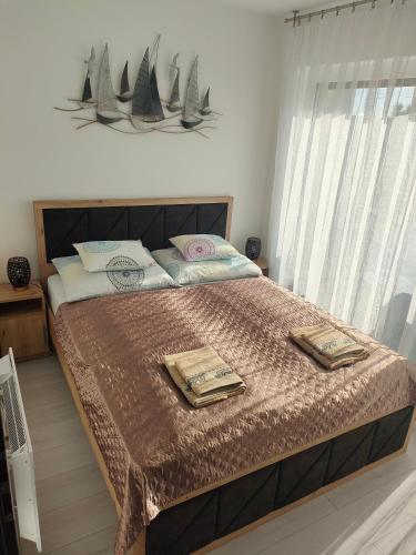a bedroom with a large bed with two plates on it at Borics Apartman in Balatonföldvár