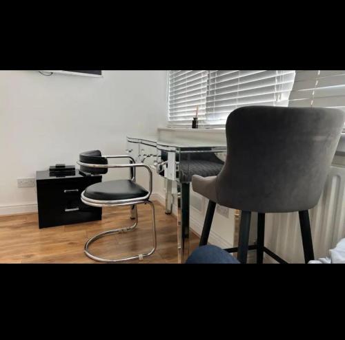 a desk and a chair in a room at An En-suite with a mini kitchen and a work space in London
