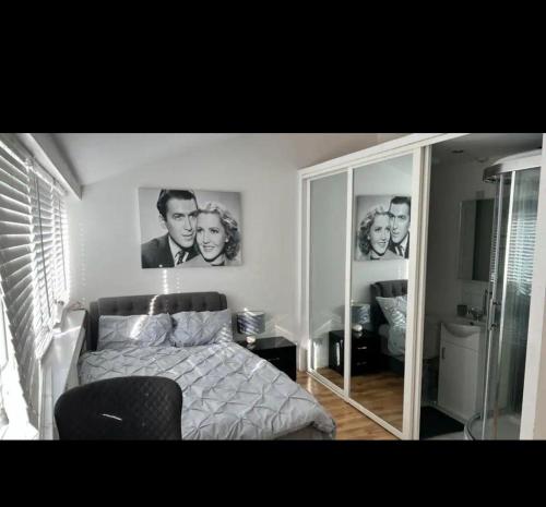 a bedroom with a bed and a large mirror at An En-suite with a mini kitchen and a work space in London