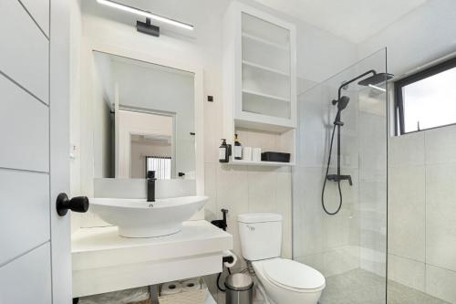 ein Badezimmer mit Waschbecken, Toilette und Dusche in der Unterkunft Atrium Apartments - Nutmeg Nook in Grand Anse