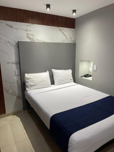 a bedroom with a large bed with white and blue sheets at HOTEL BOUTIQUE JAYCO in San José Iturbide