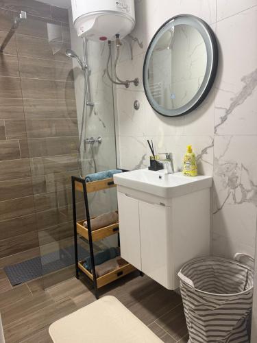 une salle de bain avec un lavabo et une douche avec un miroir dans l'établissement Jahorina, Bosna i Hercegovina - Moja planina, à Trnovo