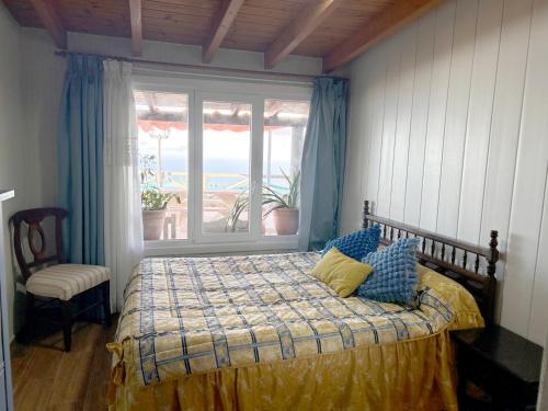 a bedroom with a bed and a large window at TENERIFE ECOLIFE HOUSES by APARTAMENTOS ESTRELLA DEL NORTE in Garachico