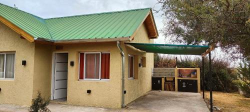 a small yellow house with a green roof at Antar Mouna in Cortaderas