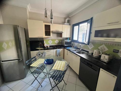 a kitchen with a refrigerator and some chairs in it at Villa Nouryan l'Azur of Carthage in La Marsa