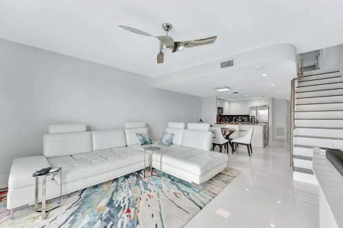 a white living room with a white couch and a table at Waterfront Two-Bedroom Townhome with Canal View in Highland Beach