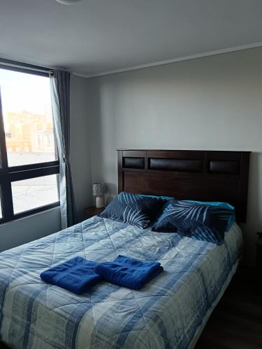 a bedroom with a bed with two blue pillows at Depto en Valparaíso centro in Valparaíso