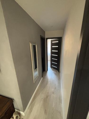 a hallway with a door and a wooden floor at Apartmánový byt VYHNE in Vyhne