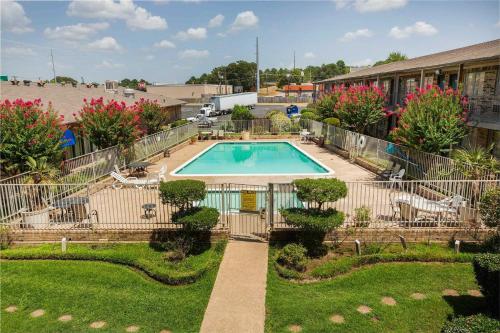 a swimming pool in a yard next to a building at OYO Hotel Tyler Lindale in Tyler