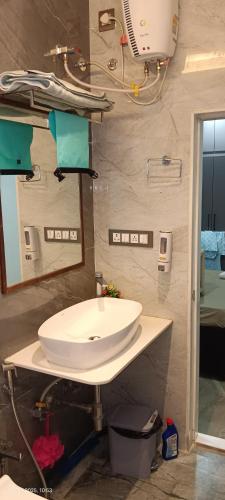 a bathroom with a white sink and a mirror at Om Niwas in Bhuj