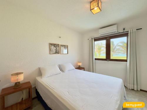 a bedroom with a white bed and a window at Reserva Retirinho B in Aracati