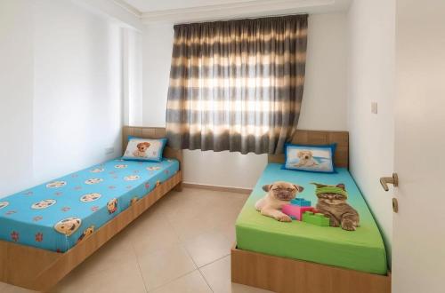 two twin beds in a room with two dogs at Le paradis in Martil