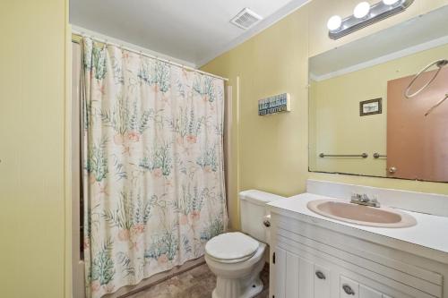 a bathroom with a toilet and a shower curtain at Star of the Sea in Virginia Beach