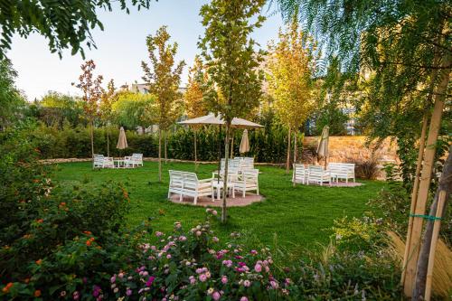 um conjunto de cadeiras e guarda-sóis em um jardim em طريق المطار بوليفارد الامعري em Amã