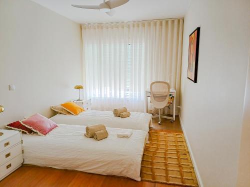 a bedroom with two beds and a chair at Sea & City Escape in Matosinhos