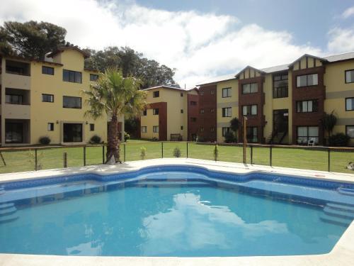una piscina frente a unos edificios de apartamentos en Complejo Ostra Negra, en Valeria del Mar