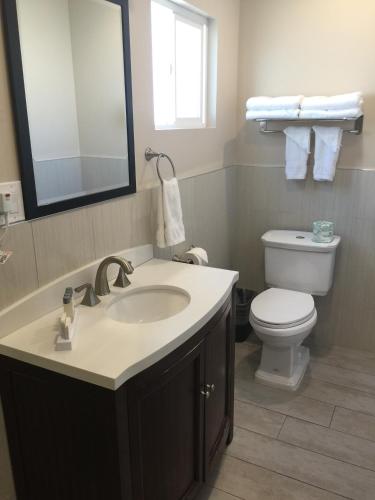 a bathroom with a sink and a toilet and a mirror at El Royale Hotel - Near Universal Studios Hollywood in Los Angeles