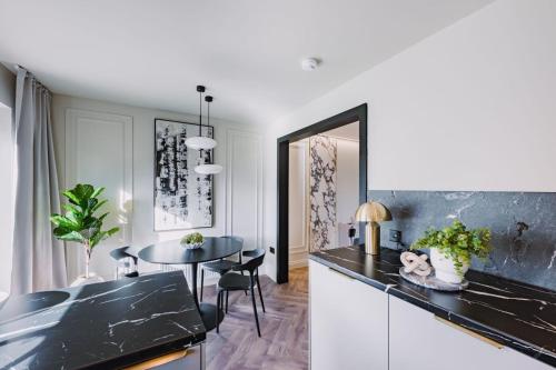 a kitchen with a black counter top and a table at JW Executive ApartHouse in Glasgow
