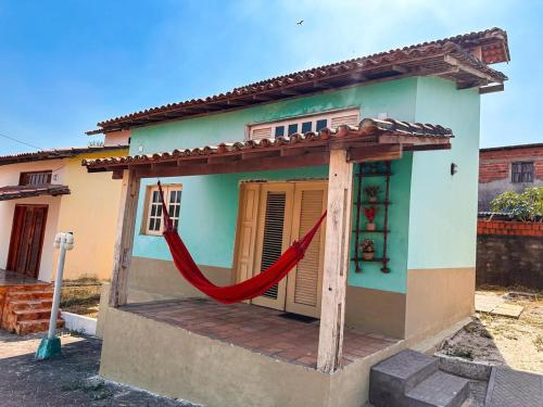 a small house with a red hammock in front of it at JGM chalés in Barreirinhas