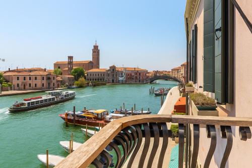 un puente sobre un río con barcos en él en MURANO Suites BOUTIQUE Apartments adults only, en Murano