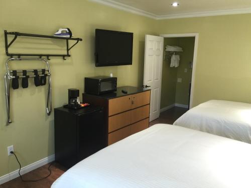 a hotel room with two beds and a tv and a bedroom at El Royale Hotel - Near Universal Studios Hollywood in Los Angeles