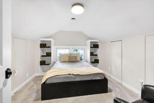 a bedroom with a large bed with white walls at MidTown Cozy Cottage in Indianapolis