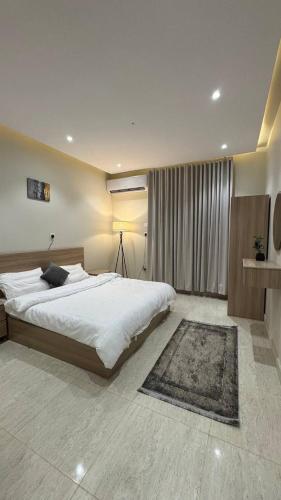 a bedroom with a large white bed and a rug at Rest home in Tabuk