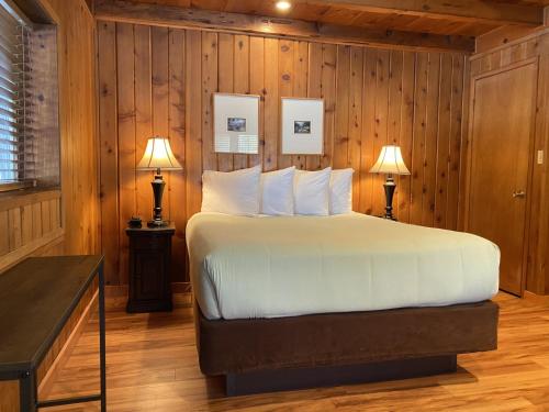 een slaapkamer met een bed met houten wanden en 2 lampen bij Timberline Lodge - Arnold - Bear Valley - Murphys in Arnold
