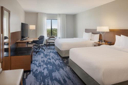 a hotel room with two beds and a desk at Fairfield Inn & Suites by Marriott Lincoln Southeast in Lincoln